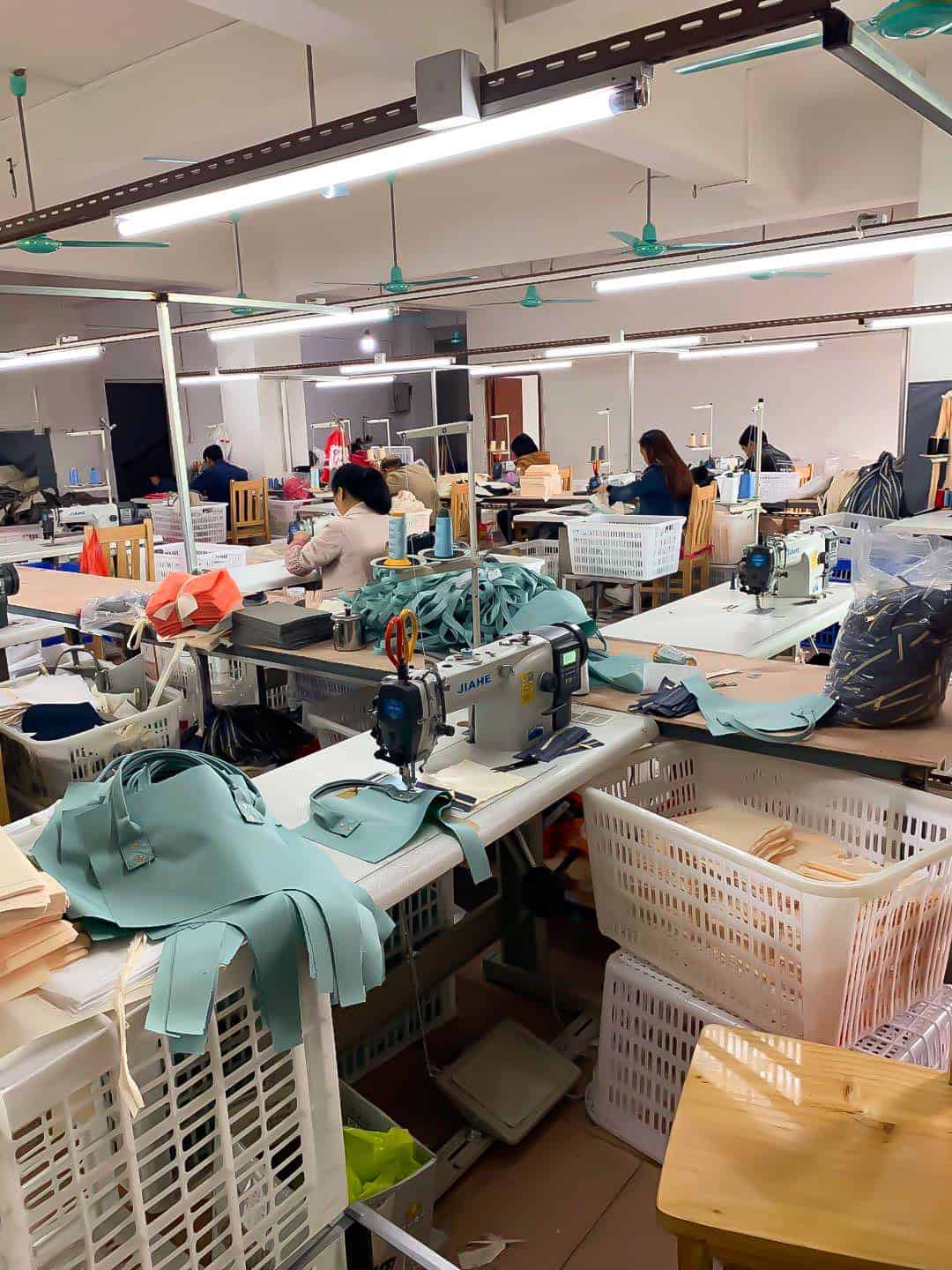 a room with many sewing machines and people working
